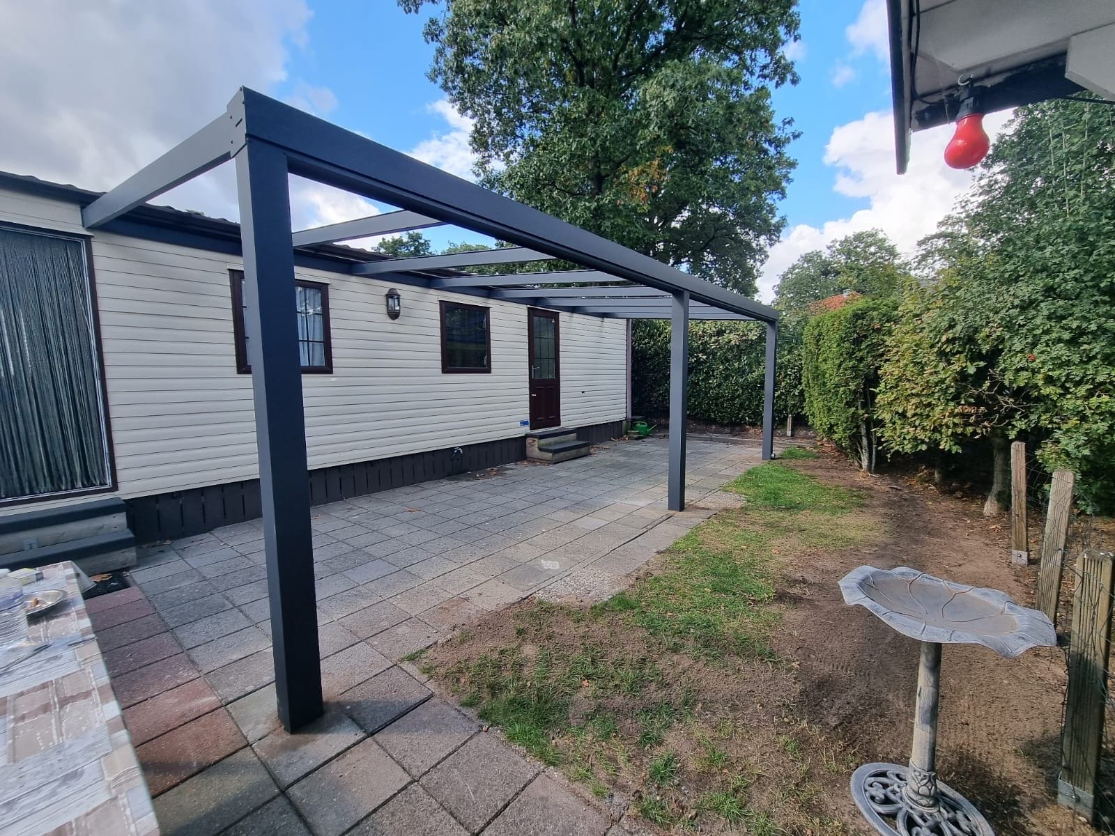 Aluminium frame met staanders en dakliggers tijdens de montage van een Holland Veranda overkapping